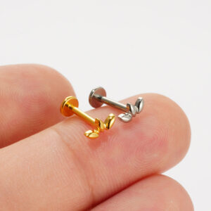 Fingertip size comparison of Gold and Silver titanium graduated V-chevron studs to show real-life scale.